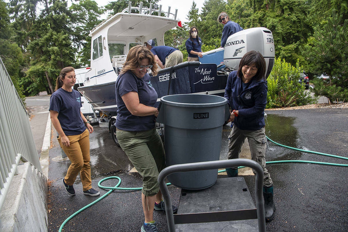 aquarists unload and hose the boat