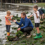 a family finds items on the shore during Explore the Shore